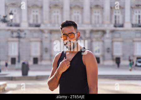 Porträt eines lateinischen Touristen, der vor dem Hintergrund des Königspalastes in madrid posiert Stockfoto