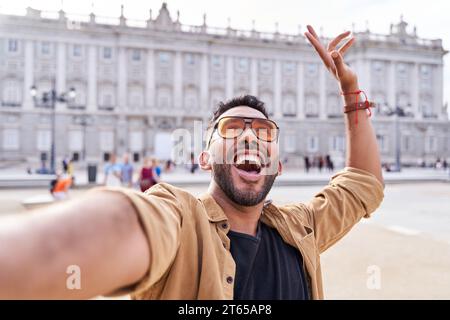 Junge lateinische Touristen, die Madrid besuchen. Ein Mann, der ein Selfie im Königspalast in Madrid macht. Stockfoto
