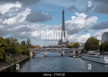 Ein Zug überquert eine Brücke über die seine mit dem Eiffelturm im Hintergrund in Paris Stockfoto