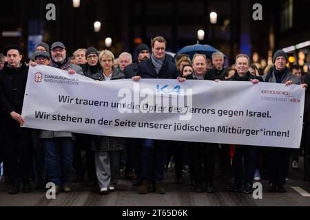 Köln, Deutschland. November 2023. Hendrik Wüst (M, CDU), Ministerpräsident von Nordrhein-Westfalen, nimmt an einem stummmarsch vor dem Gedenktag für die Pogromnacht vor 85 Jahren Teil. Kirchenverbände wollen mit dem Stillen marsch der Opfer der Angriffe auf Israel gedenken. Quelle: Rolf Vennenbernd/dpa/Alamy Live News Stockfoto