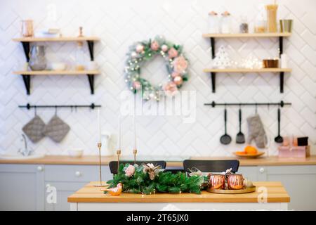 Dekoriert für Weihnachten und Neujahr helle Innenausstattung der Küche, dekoriert mit Girlande, Glühbirnen Hintergrund, Küchentisch mit Kerzen in Kerzen Stockfoto