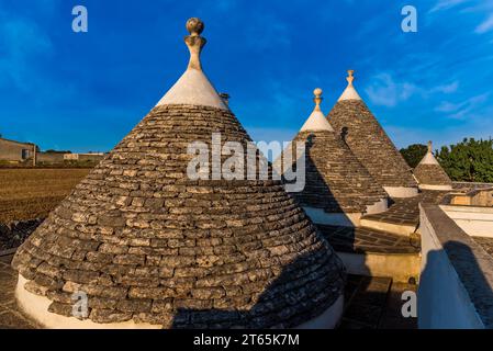 Konische Kalksteindächer traditioneller Trulli-Häuser in der Nähe von Martina Franca, Bari, Italien im Sommer. Stockfoto