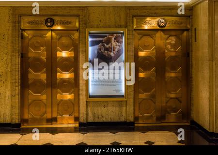 Goldene Aufzüge im Palmer House, erbaut 1873. Das Palmer House war das erste Hotel in Chicago mit Aufzügen. Beleuchtetes Schild für das berühmte Gebäck, den von Bertha Palmer erfundenen Brownie. Für die Weltausstellung 1893 wurde der heute weltberühmte Brownie im Palmer House in Chicago geschaffen. Es wird noch heute an seinem Ursprungsort, der Lockwood Patisserie im Palmer House, einem Teil der Hilton-Kette, angeboten. Chicago, Illinois, Usa Stockfoto