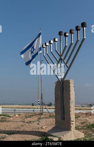 Eine große, achtverzweigte Hanukka-Menora aus Metall, die auf einem Betonfundament errichtet und entlang einer Autobahn im Jordantal in Israel aufgestellt wurde. Stockfoto