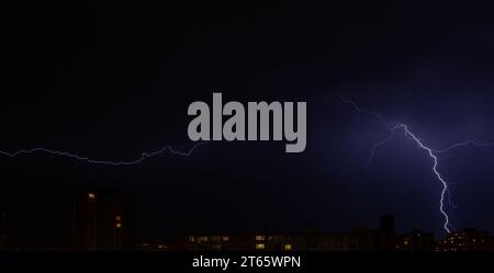 Nächtliche Blitze, Blitze über der Stadt, dramatische Szenen am Nachthimmel Stockfoto