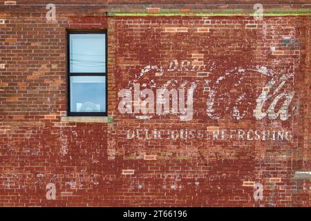 Verwittertes und verblasstes Coca-Cola-Werbetafel, gemalt auf einer Backsteinwand eines historischen Gebäudes in der Innenstadt von Cheyenne, Wyoming Stockfoto