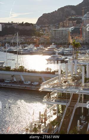 Monaco, Monte Carlo, 18. Oktober 2022: Sonnenuntergang Panorama von Port Hercule, vertäute Mega-Yacht, Sonnenspiegelung Stockfoto