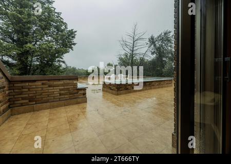 Terrasse eines Wohnhauses mit weißem Couchtisch und passenden Metallstühlen Stockfoto