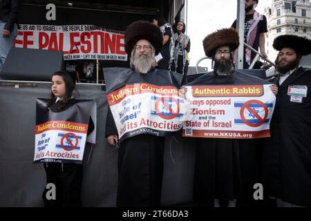 4. November 2023, Washington, District of Columbia, Vereinigte Staaten: Rabbi Yisroel Dovid Weiss (zweiter von links) und Rabbi Dovid Feldman (dritter von links) stehen mit anderen Mitgliedern von Neturei Karta während der pro-palästinensischen Kundgebung am 4. November 2023 auf der Freedom Plaza in Washington, DC. Die Gruppe, bekannt für ihre entschiedene Opposition gegen den Zionismus und den Staat Israel, zeigt Banner mit der Aufschrift "Judaismus verurteilt den Staat "'Israel"" und seine Gräueltaten" und behauptet ihre Identität als "authentische Rabbiner", die sich historisch gegen den Zionismus ausgesprochen haben. Dieser Auftritt von Neturei Karta unterstreicht die Stockfoto