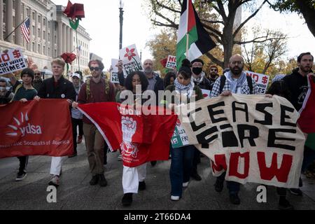 4. November 2023, Washington, District of Columbia, Vereinigte Staaten: Aktivisten der Young Democratic Socialists of America (YDSA) schließen sich einer größeren Koalition von Demonstranten in der Nähe des Washington Monuments an und treten für einen Waffenstillstand im andauernden Konflikt ein. Sie halten Banner mit klaren Forderungen: „WAFFENSTILLSTAND JETZT“ und „KEIN $ FÜR KRIEGSVERBRECHEN“. Sie marschieren am 4. November 2023 in Richtung Freedom Plaza in Washington, DC. Ihre sichtbare Präsenz und ihre lautstarken Handlungsaufrufe stellen eine breite demografische einheit unter dem Pro-palästinensischen Banner dar, die sofortigen Wandel und ein Ende der Feindseligkeiten fordert. (Kreditbild: © Stockfoto