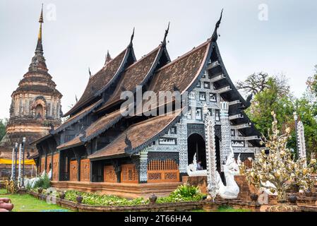 Mit alten Stupa dahinter, die königliche Asche mehrerer Könige beherbergt. Haupttempel mit kunstvoller Dekoration, mit weißer Fassade, aus Teakholz, mit schwarzem Lack bedeckt Stockfoto