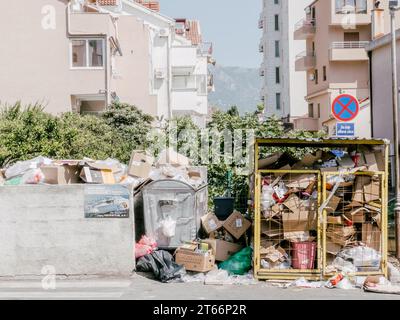 Budva, Montenegro – 05. august 2023: Überfüllte Mülltonnen neben Hochhäusern Stockfoto