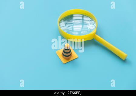 Befestigung, Wartung und im Bau befindliches Konzept. Lupe mit Verkehrskegeln. Stockfoto
