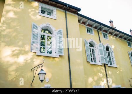Rechteckige kleine Gitterfenster unter dem Dach eines alten Herrenhauses Stockfoto