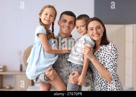 Soldat mit seinen kleinen Kindern und seiner Frau zu Hause Stockfoto