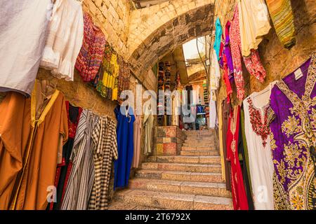 Jerusalem, Israel. September 2023. Blick auf eine Gasse mit Stufen, einem Steinbogen und Kleidung, die an den Wänden hängen, im armenischen Viertel der Altstadt Stockfoto