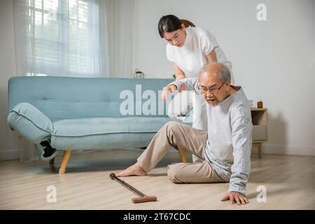 Ein alter Mann mit Gehstock fällt auf den Boden und die Enkelin Camp, um zu helfen Stockfoto