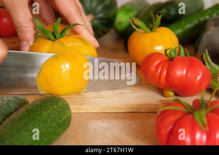 Frische reife große Tomaten, Auberginen, Gemüse auf einem Küchenarbeitsplatz aus Holz. Hintergrund vieler Rohgemüse. Tomaten, Gurken. Herd zu Hause macht eine Stunde Stockfoto