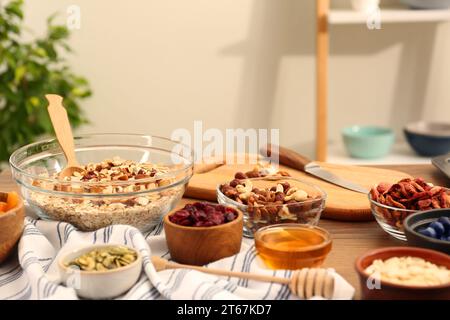 Müsli machen. Nüsse, Haferflocken und andere Zutaten auf dem Tisch Stockfoto