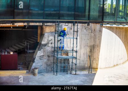 afroamerikaner Bauarbeiter kletterten auf Gerüste und arbeiteten an einer Fassade an einem Gebäude Stockfoto