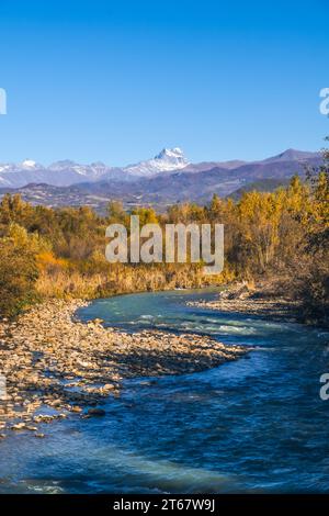 Wunderschöne Herbstlandschaft Bergfluss, gelbliche Bäume, Berge mit schneebedeckten Gipfeln. Bezaubernde Berglandschaft im Herbst. Vertikales Foto Stockfoto