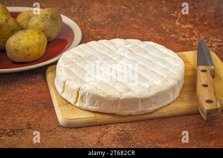 reblochon Käse und gekochte Kartoffelgerichte auf einem Tisch Stockfoto