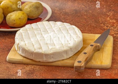 reblochon Käse und gekochte Kartoffelgerichte auf einem Tisch Stockfoto