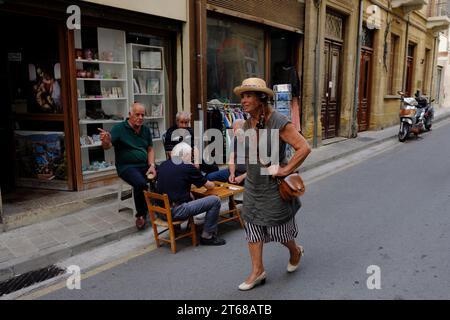 Frau geht an Männern vorbei, die Backgammon spielen in Nikosia, Zypern Stockfoto