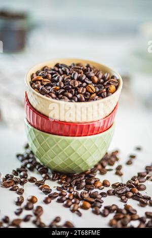 Geröstete Kaffeebohnen in einer Schüssel auf dem weißen Küchentisch. Stockfoto