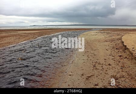 Ein Blick auf den Abhainn Chuil, der zum Meer fließt, über den Traigh Chuil Beach an der Ostküste der Isle of Lewis, Äußere Hebriden, Schottland. Stockfoto