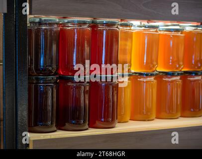 Honigladen-Theke voller Honiggläser in verschiedenen Farben mit Kopierraum für Mockup Stockfoto