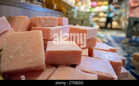 Handgemachter Korb voller handgemachter Blumenseife in einem Geschäft besteht aus Körperpflegeprodukten mit hölzernem Hintergrund Stockfoto