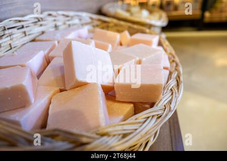 Handgemachter Korb voller handgemachter Blumenseife in einem Geschäft besteht aus Körperpflegeprodukten mit hölzernem Hintergrund Stockfoto