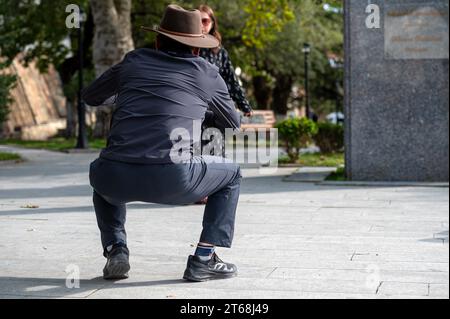 Sighnaghi, Georgia – 7. Oktober 2023: Ein hockender Mann fotografiert seine Freundin mit einem Smartphone Stockfoto