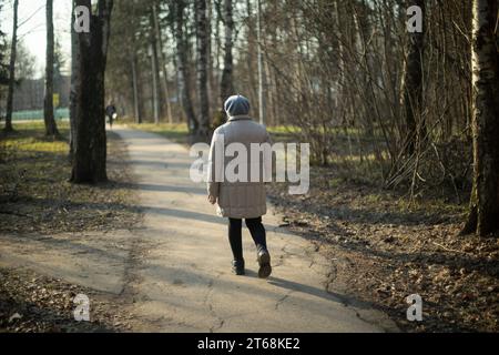 Ein älterer Mann läuft durch den Park. Rentner spazieren durch die Stadt. Alte Kleidung auf Person. Details zum Spaziergang durch den Park. Stockfoto