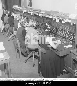 Telefonie in den 1950er. Frauen, die in einer Telefonzentrale arbeiten, als Telefonisten. Ein manuell betriebenes Telefonkommunikationssystem, bei dem die eingehenden Anrufe vom Betreiber weitergeleitet und an eine andere Telefonnummer umgeleitet wurden, in diesem Fall lokal innerhalb des Gebäudes, das ein Unternehmen oder eine Organisation mit vielen internen Telefonleitungen bedient. Die Telefonzentrale konnte Nachrichten entgegennehmen und Sie in die Warteschleife setzen, wenn die Leitung besetzt war. Schweden 1953. Kristoffersson Ref. BM71-1 Stockfoto