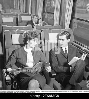 Zugfahrt in den 1960er Jahren Ein Paar im Zug, das bequem in der Kutsche sitzt und eine Zeitschrift und ein Buch liest. Schweden 1960er Jahre Kristoffersson Ref. DD118-11 Stockfoto