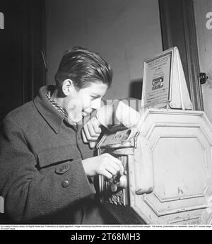 Young man at a Mutoscope, eine frühe Filmregie, die 1894 in Amerika erfunden wurde und durch Drehen nach vorne scrollen, um die Illusion von bewegten Bildern zu erzeugen. Das Mutoskop funktioniert nach dem gleichen Prinzip wie das Flipbook. Technisch funktionierte das Gerät so, dass die Bilder auf einer rotierenden Trommel sitzen und mit ca. 16 Bildern pro Sekunde angezeigt werden. Die Mutoskope sind münzbetrieben und für einen Cent zeigt dieses Mutoskop: Zelt Circus oder Intermezzo in Trikots. Schweden 1950. Kristoffersson BB43-6 Stockfoto