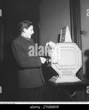 Young man at a Mutoscope, eine frühe Filmregie, die 1894 in Amerika erfunden wurde und durch Drehen nach vorne scrollen, um die Illusion von bewegten Bildern zu erzeugen. Das Mutoskop funktioniert nach dem gleichen Prinzip wie das Flipbook. Technisch funktionierte das Gerät so, dass die Bilder auf einer rotierenden Trommel sitzen und mit ca. 16 Bildern pro Sekunde angezeigt werden. Die Mutoskope sind münzbetrieben und für einen Cent zeigt dieses Mutoskop: Zelt Circus oder Intermezzo in Trikots. Schweden 1950. Kristoffersson BB43-2 Stockfoto