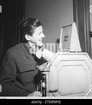 Young man at a Mutoscope, eine frühe Filmregie, die 1894 in Amerika erfunden wurde und durch Drehen nach vorne scrollen, um die Illusion von bewegten Bildern zu erzeugen. Das Mutoskop funktioniert nach dem gleichen Prinzip wie das Flipbook. Technisch funktionierte das Gerät so, dass die Bilder auf einer rotierenden Trommel sitzen und mit ca. 16 Bildern pro Sekunde angezeigt werden. Die Mutoskope sind münzbetrieben und für einen Cent zeigt dieses Mutoskop: Zelt Circus oder Intermezzo in Trikots. Schweden 1950. Kristoffersson BB43-8 Stockfoto