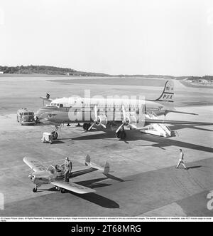 Flughafen der 1950er Jahre. Ein Douglas DC-4 von Pan American World Airways 'Clipper Oslo' PA-A N88944 wird vorbereitet und vor dem Start betankt. Am Flügel am Ende der Gasleitung vom Lkw ist ein Mann zu sehen. Das kleinere Propellerflugzeug ist eine Ercoupe 415 SE-BNA mit einem Mann mit Aktentasche, der kurz davor steht, in das Flugzeug einzusteigen. Schweden 1953. Kristoffersson Ref. BM42-3 Stockfoto