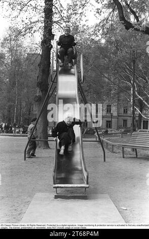 Spielplatz in den 1950er Jahren Kinder werden auf einer Rutsche in einem Park in Stockholm gesehen, Schweden 1954. Kristoffersson Ref. 1-38 Stockfoto