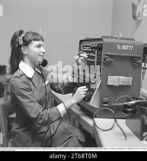 Schwedischer Freiwilliger Frauenverteidigungsdienst in Älvkarleö 1962. Lottorna ist eine Hilfsorganisation der schwedischen Heimatgarde, die Teil der schwedischen Streitkräfte ist. Abbildung eines der Mitglieder, die eine Telefonzentrale betreiben und eingehende und ausgehende Telefonanrufe über eine Zentrale verbinden. Stockfoto