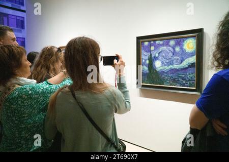 Manhattan, USA, 30. Oktober 2023: Besucher des MOMA in New York treffen sich um Vincent van Goghs „The Starry Night“ aus dem Jahr 1889. Das Gemälde, teilweise gemacht Stockfoto