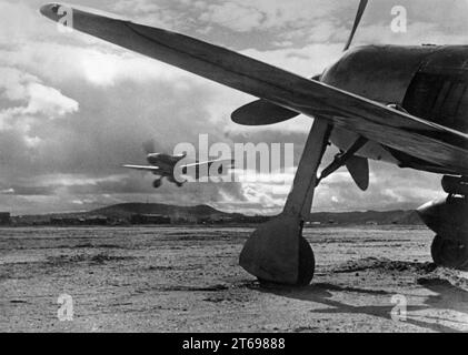 Rechts eine Focke Wulf FW 190, links eine Messerschmitt ME Bf 109 landet auf einem Feldflugplatz an der Front in Finnland. [Automatisierte Übersetzung] Stockfoto