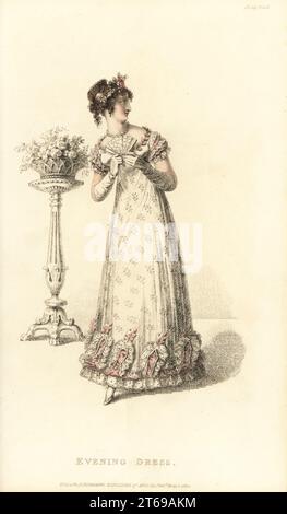 Regency Dame in Spitze Abendkleid mit Blättern verziert. Niedriges Kleid aus Urlings-Spitze im Blattmuster, weißer Satinschlupf, Kranz aus rosafarbenen Blättern an der Brust, Kunstblumen und Perlenkamm im Haar. Entworfen von Miss Pierpoint, 9 Henrietta Street, Covent Garden. Vol. 9, Plate 39, 1. Mai 1820. Handkolorierter Kupferstich von Thomas Uwins aus Rudolph Ackermanns Repository of Arts, Strand, London. Stockfoto