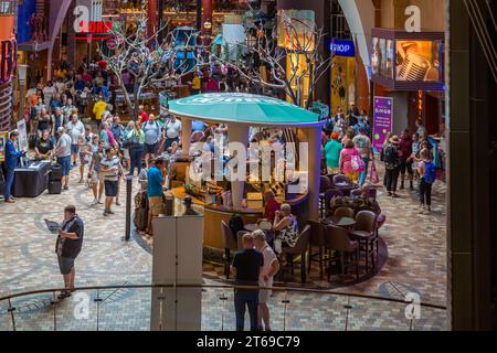 Kreuzfahrtpassagiere treffen sich im Bereich der Promenade Shops, nachdem sie an Bord des Kreuzfahrtschiffs Royal Caribbean Allure of the Seas gegangen sind. Stockfoto