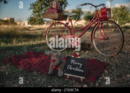 Rotes Fahrrad mit Weihnachtsgeschenken in der Natur. Stockfoto