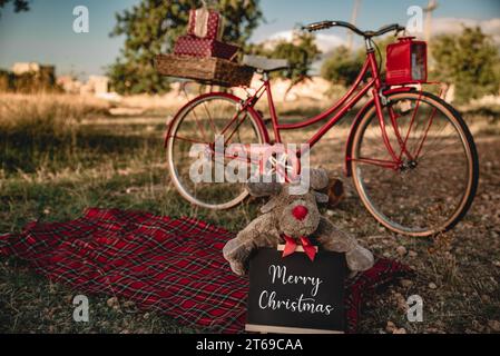 Rotes Fahrrad mit Weihnachtsgeschenken in der Natur. Stockfoto