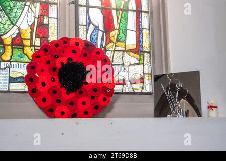 Beaconsfield, Großbritannien. November 2023. In der Stadt Beaconsfield in Buckinghamshire werden Vorbereitungen für den Waffenstillstand und den Gedenktag an diesem Wochenende vorbereitet. Wunderschöne gehäkelte Mohnkränze und Gedenkkreuze sind in der Pfarrkirche St. Maria und Allerheiligen zu sehen, in Erinnerung an die tapferen Soldaten und Frauen, die im Ersten und Zweiten Weltkrieg ihr Leben verloren haben und für unsere Freiheit kämpften. Es gibt Bedenken, dass der Pro-Palästina-marsch in London und anderen Städten Großbritanniens an diesem Wochenende zu Gewalt auf den Straßen führen könnte. Quelle: Maureen McLean/Alamy Live News Stockfoto